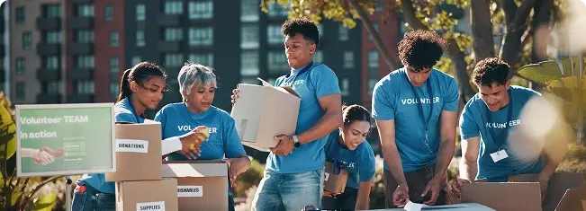 Volunteers sorting donations into boxes outdoors.