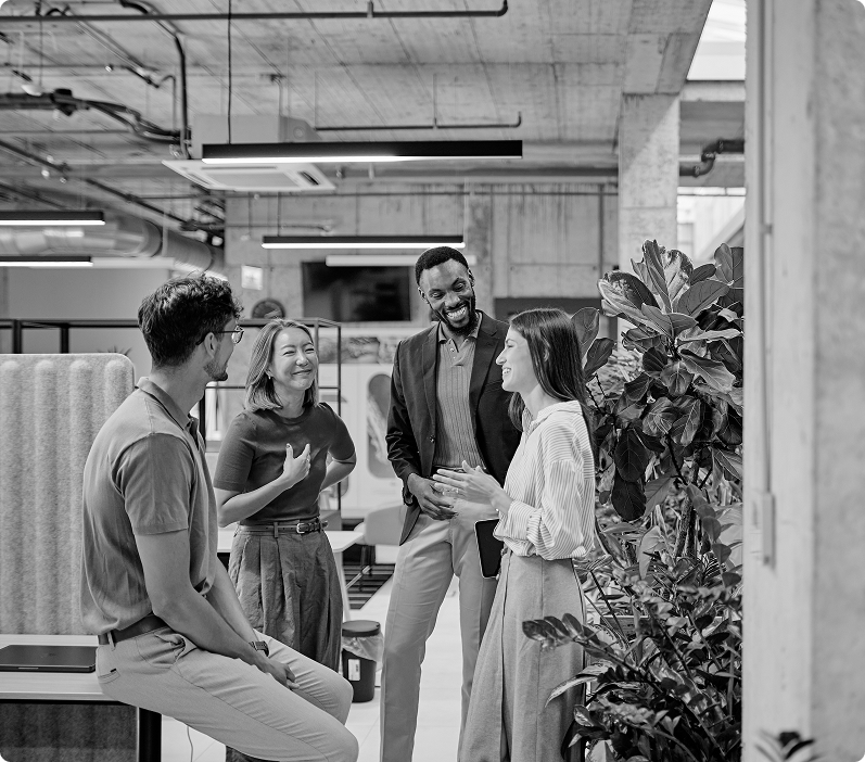Four colleagues talking together in an open office.