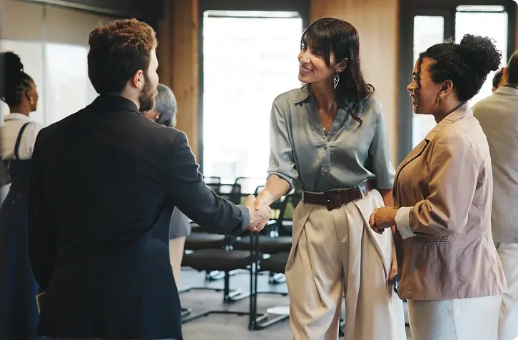 Business professionals greeting one another with a handshake.