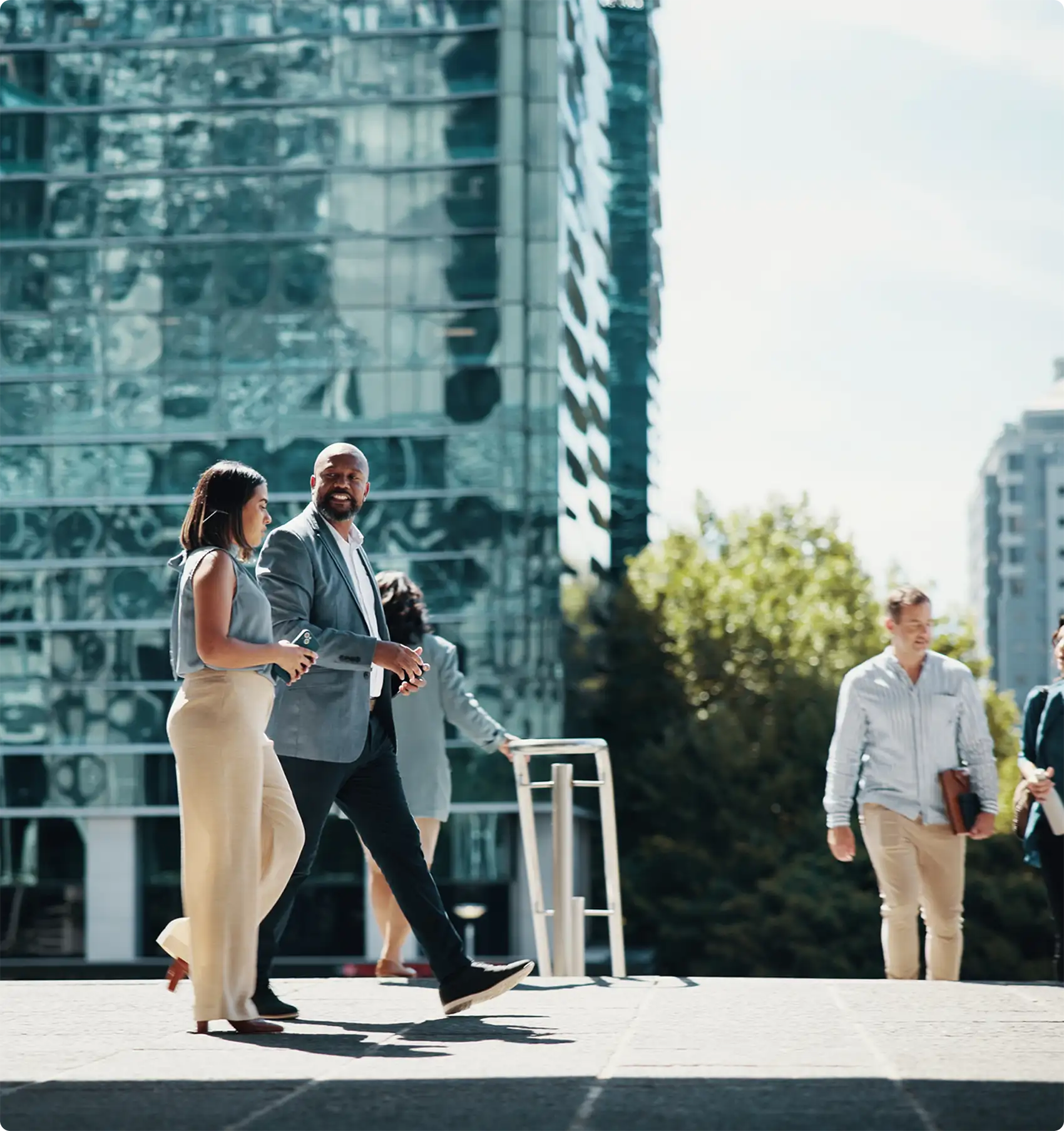 Two professionals talking as they walk outside an office building.